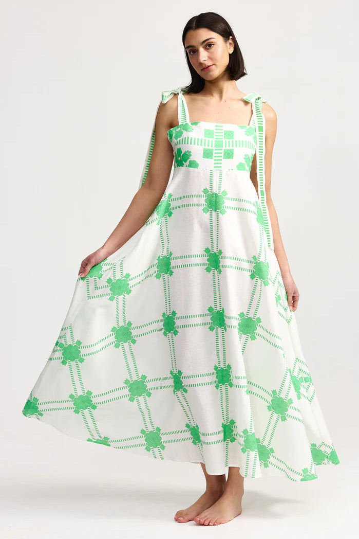 Woman wearing a white dress with green patterns on a white background. Aston Studio Pippa Dress Mediterranean Fern