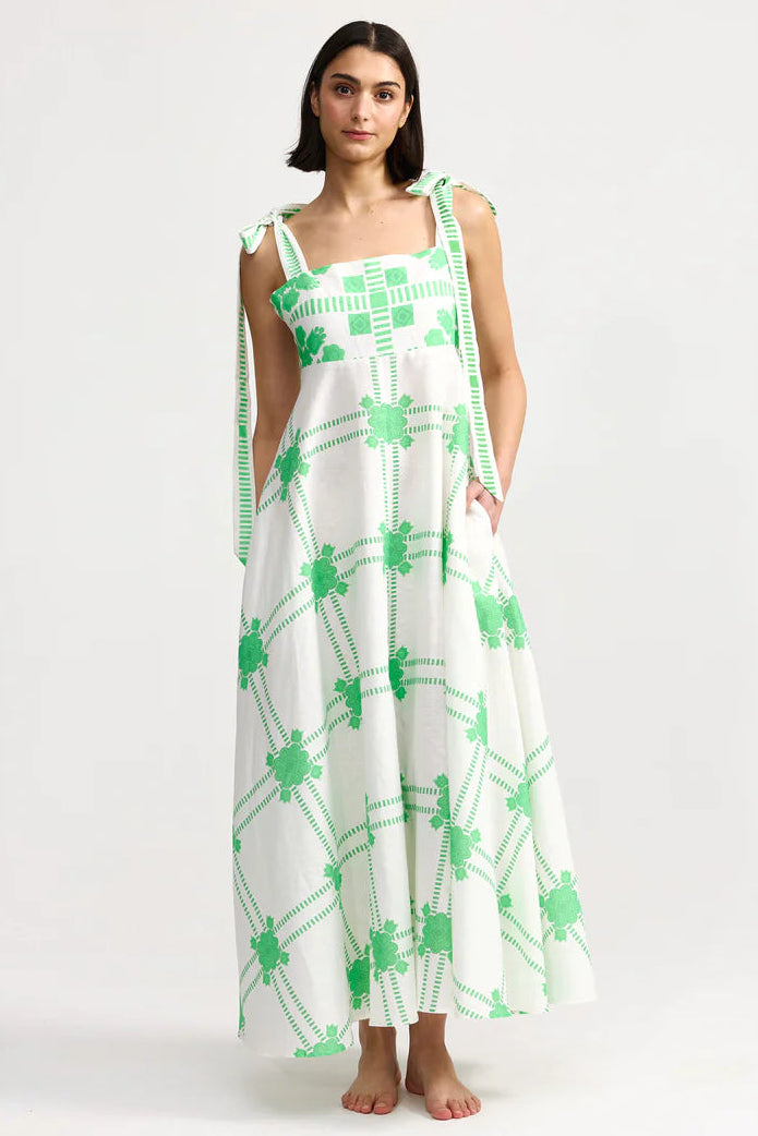 Woman wearing a white dress with green patterns on a white background. Aston Studio Pippa Dress Mediterranean Fern