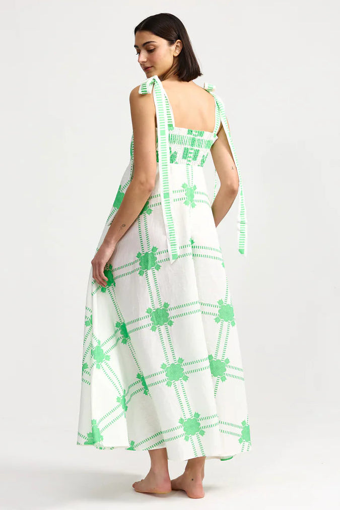 Woman wearing a white dress with green patterns on a white background. Aston Studio Pippa Dress Mediterranean Fern
