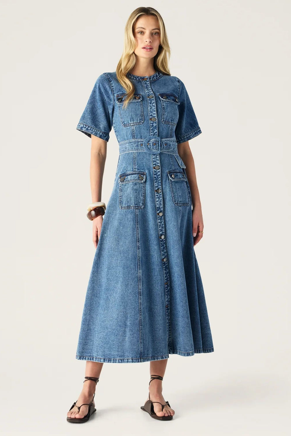 Woman wearing a blue denim dress on a white background