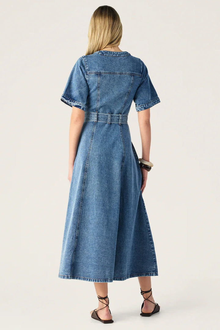 Woman wearing a blue denim dress on a white background