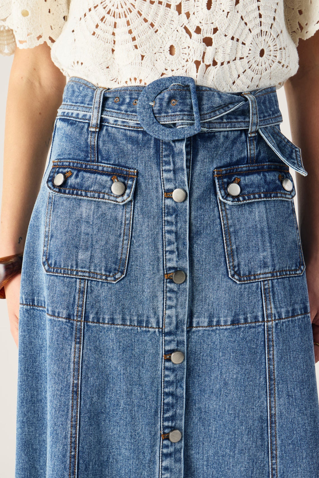 Denim skirt with button details on a plain background