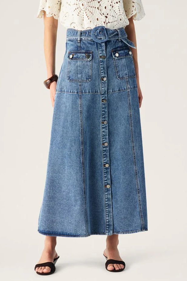 Person wearing a long denim skirt on a white background