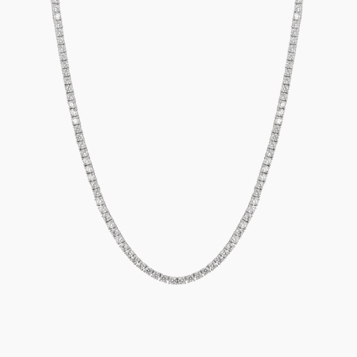 A silver tennis chain necklace paved with small clear stones, shown against a plain white background.