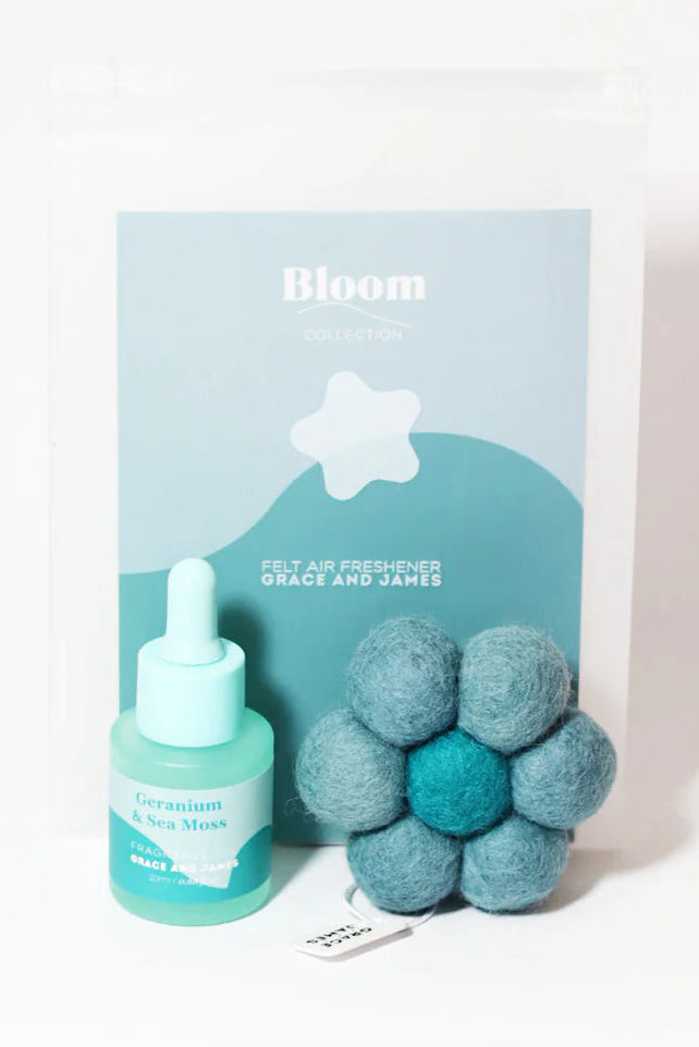 Bottle of fragranced oil and flower shaped felt air freshener with 'Bloom' packaging on a white background