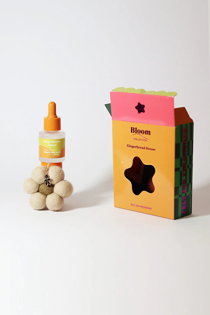 Fragranced oil bottle with dropper, flower shaped felt air freshener, and box labeled 'Bloom' on a white background