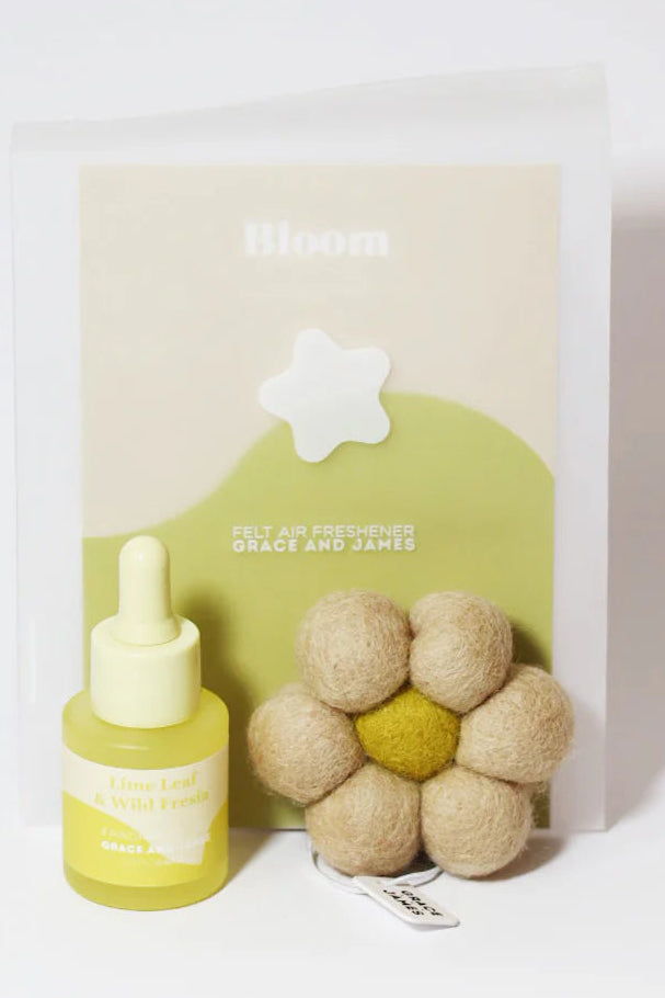 Bottle with oil dropper and flower shaped felt air freshener on a white background. Lime Leaf & Fresia