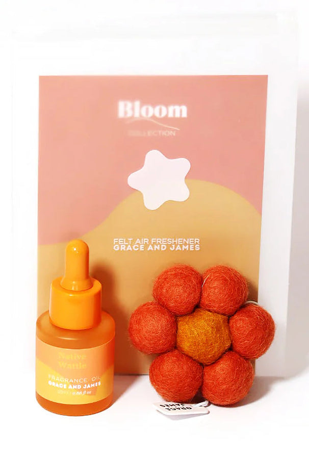Bottle of fragranced oil, flower shaped felt air freshener, and a box labeled 'Bloom' on a white background