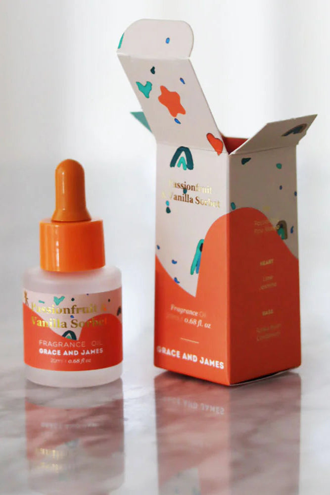 Fragranced oil bottle and box of Grace and James passionfruit vanilla on a white background