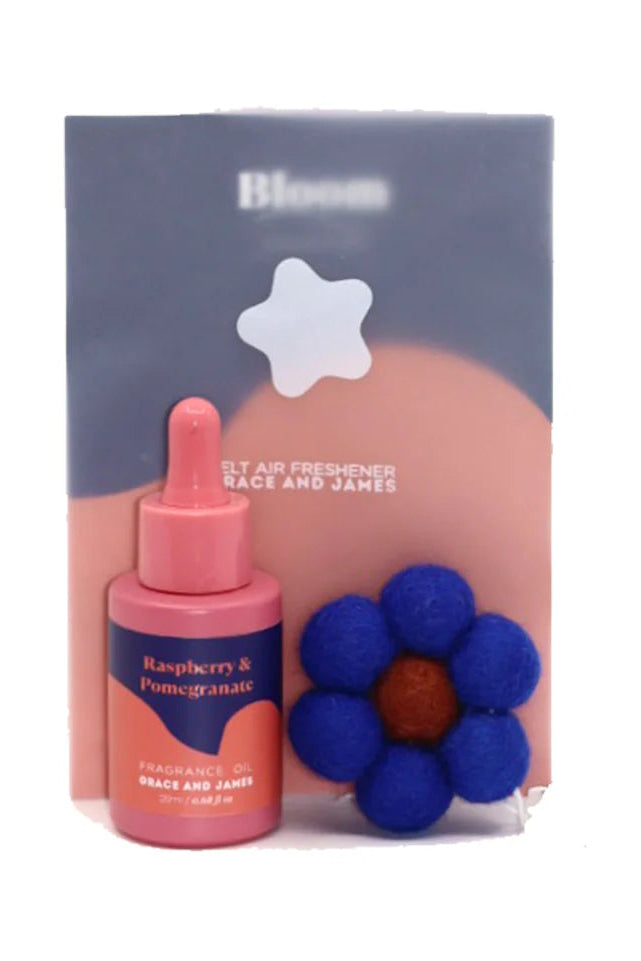 Pink fragranced oil bottle with dropper and blue flower shaped felt air freshener on a white background