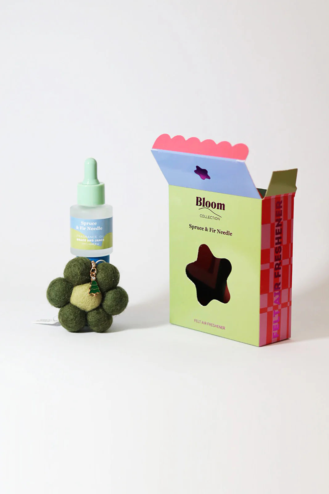 Fragranced oil bottle, flower shaped felt air freshener with Christmas charm in a box labeled 'Bloom' on a white background