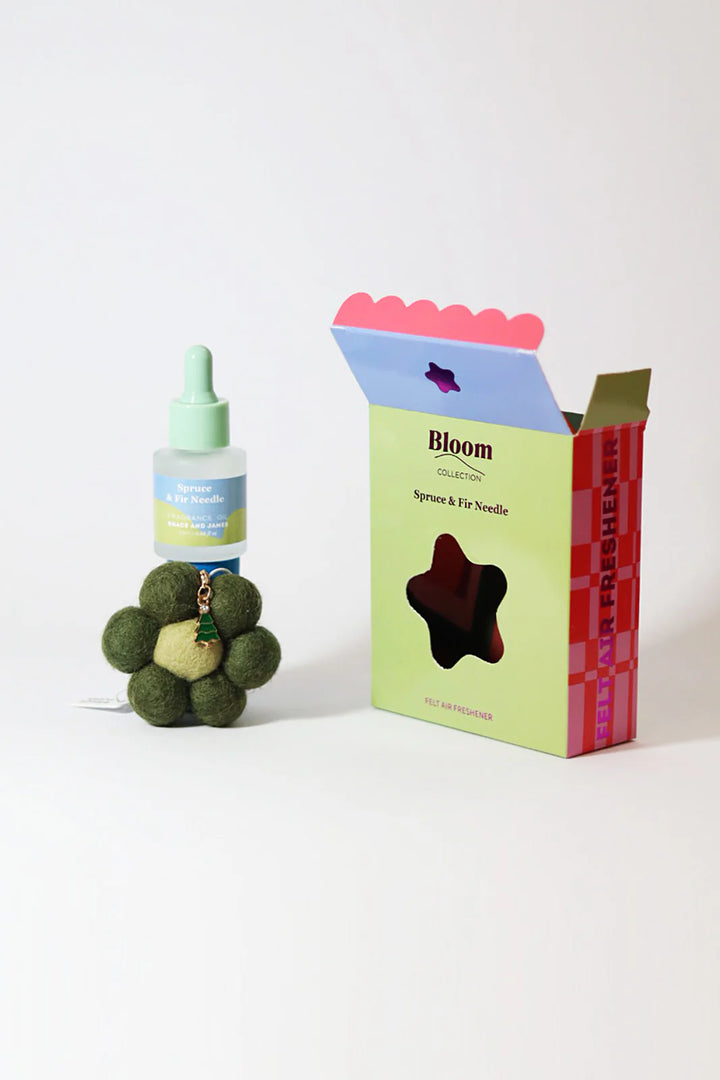 Fragranced oil bottle, flower shaped felt air freshener with Christmas charm in a box labeled 'Bloom' on a white background