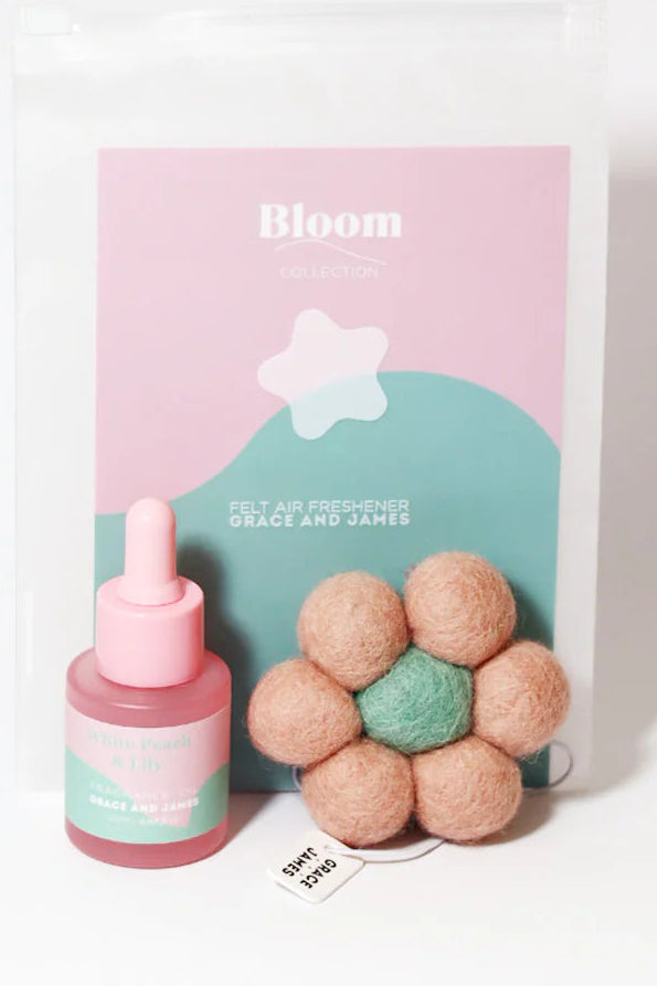 Product packaging with a fragranced oil bottle and flower-shaped felt air freshener on a white background