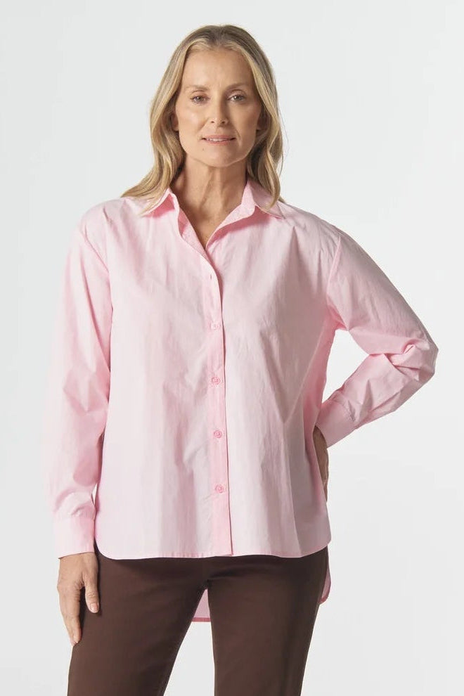 Woman wearing a pink shirt and brown pants on a white background