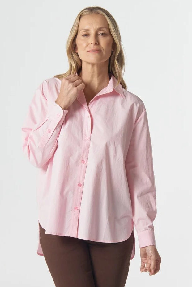Woman wearing a pink shirt and brown pants on a white background