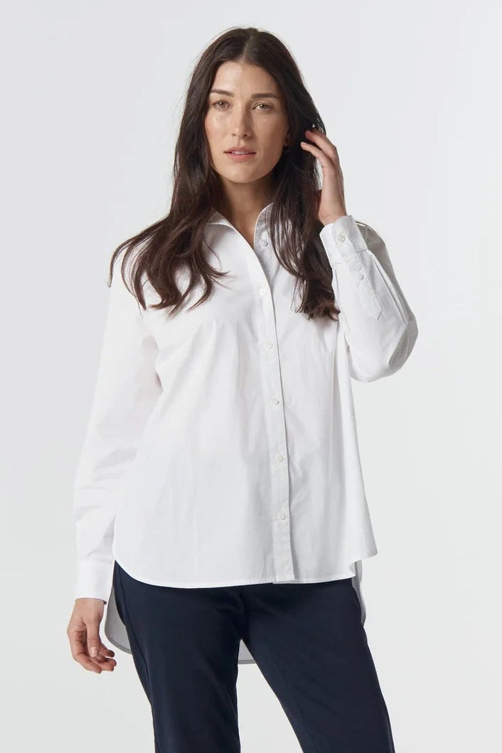Woman wearing a white shirt and dark pants on a white background