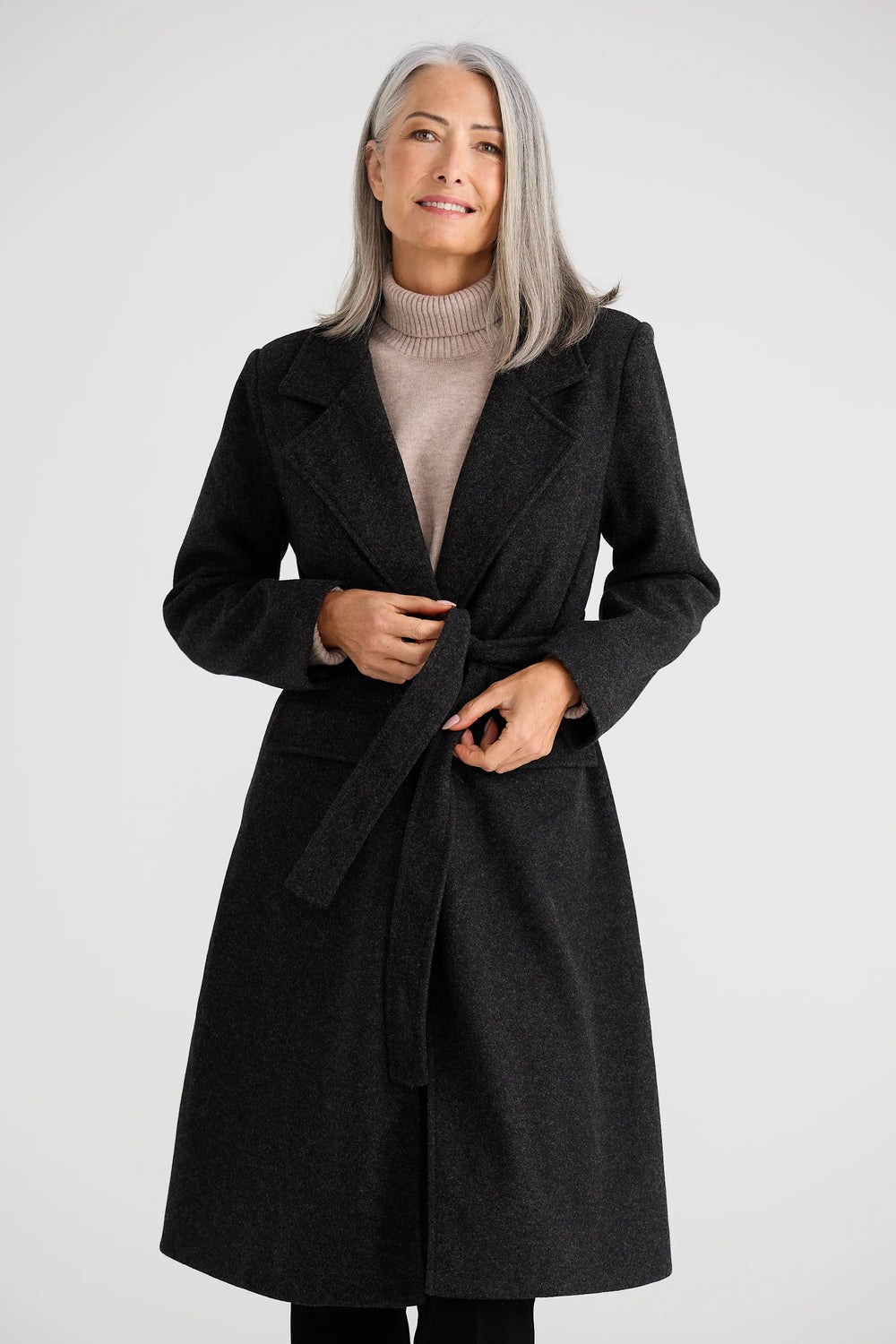 Woman wearing a dark gray coat on a white background