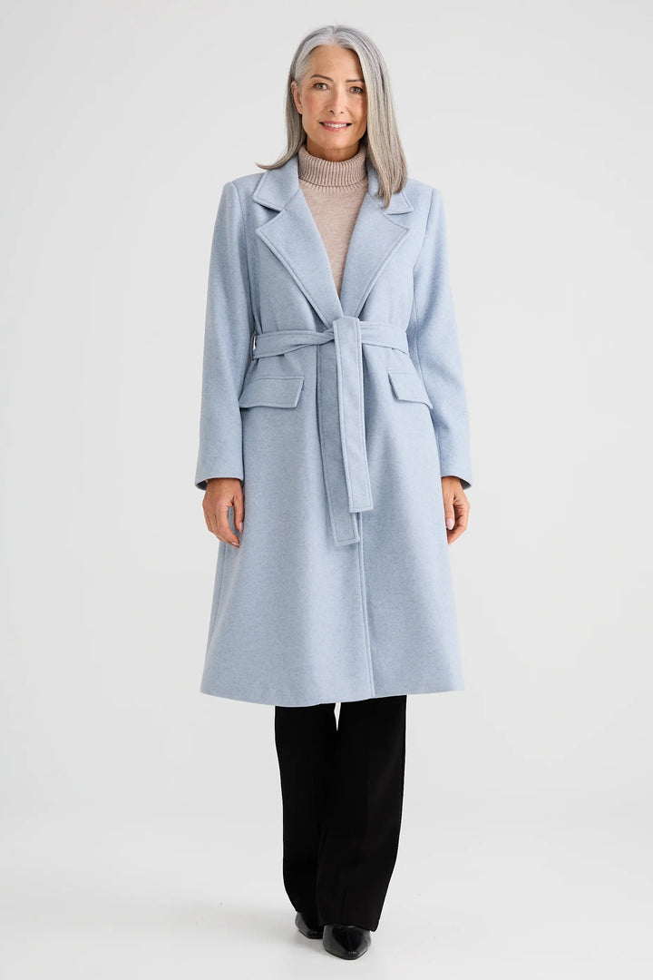 Woman wearing a light blue coat on a white background