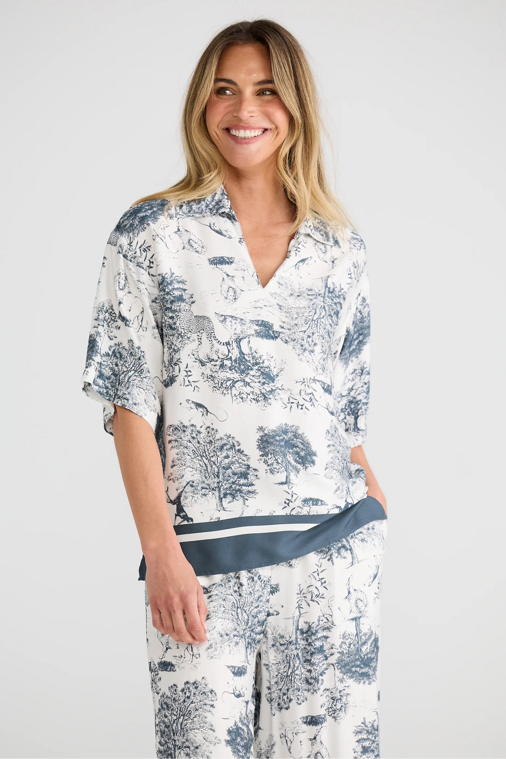 Woman wearing a white floral dress with a blue belt on a white background