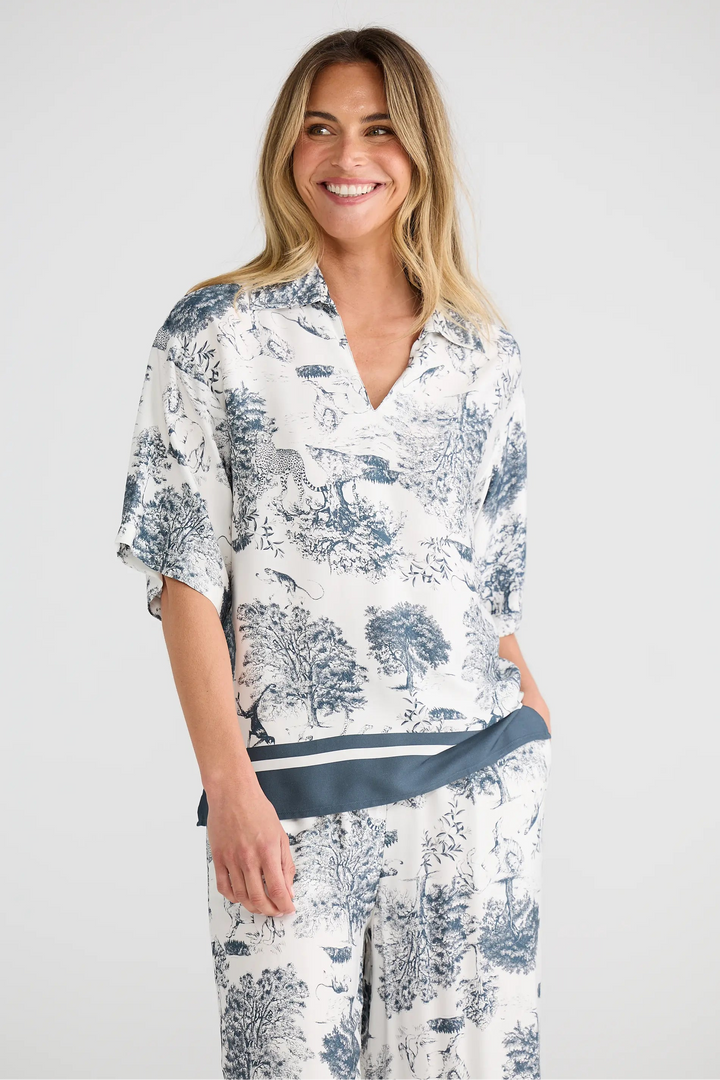 Woman wearing a white floral dress with a blue belt on a white background