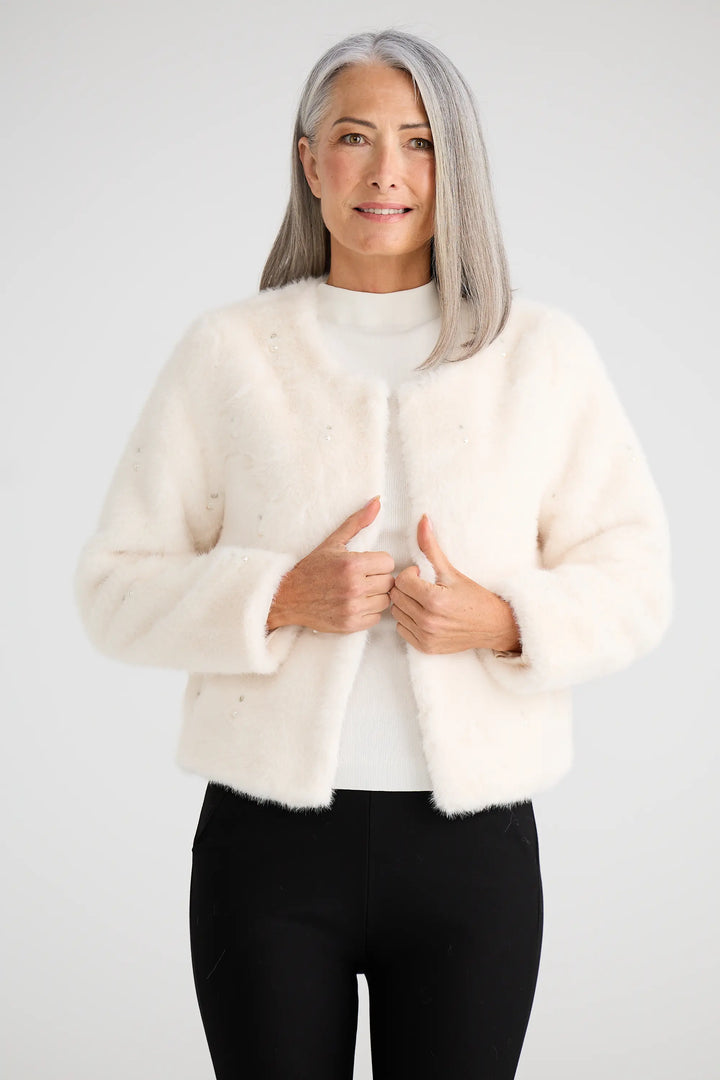 Woman wearing a cream fur coat on a white background