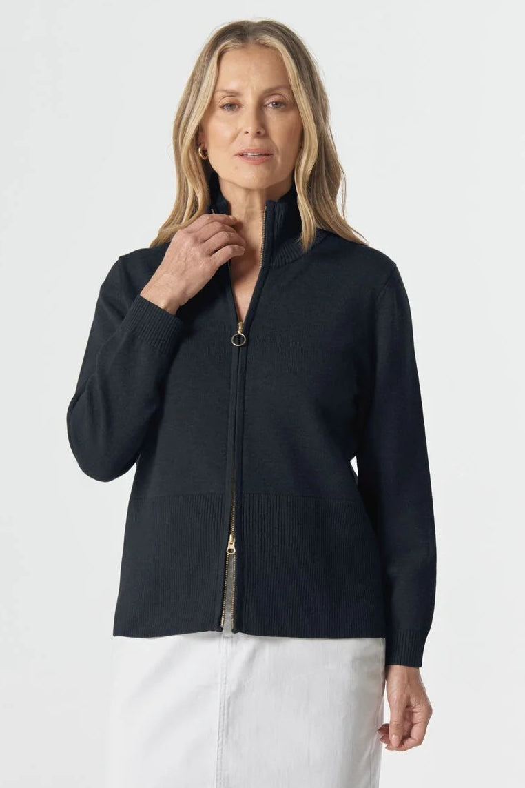 Woman wearing a navy cardigan and white skirt on a white background