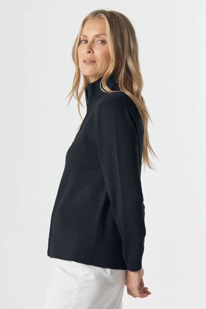 Woman wearing a navy cardigan and white skirt on a white background