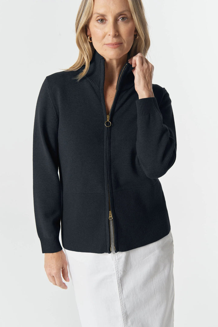 Woman wearing a navy zip up cardigan against a white background