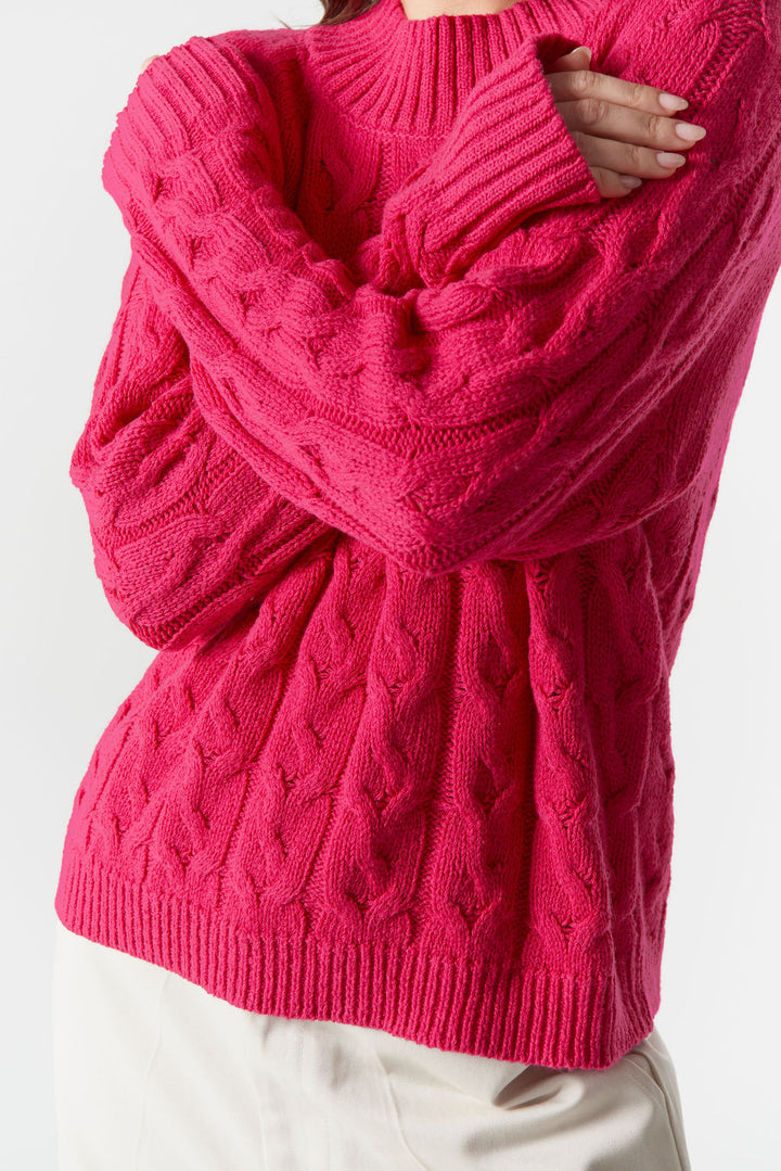 Person wearing a bright pink knitted sweater with a white background