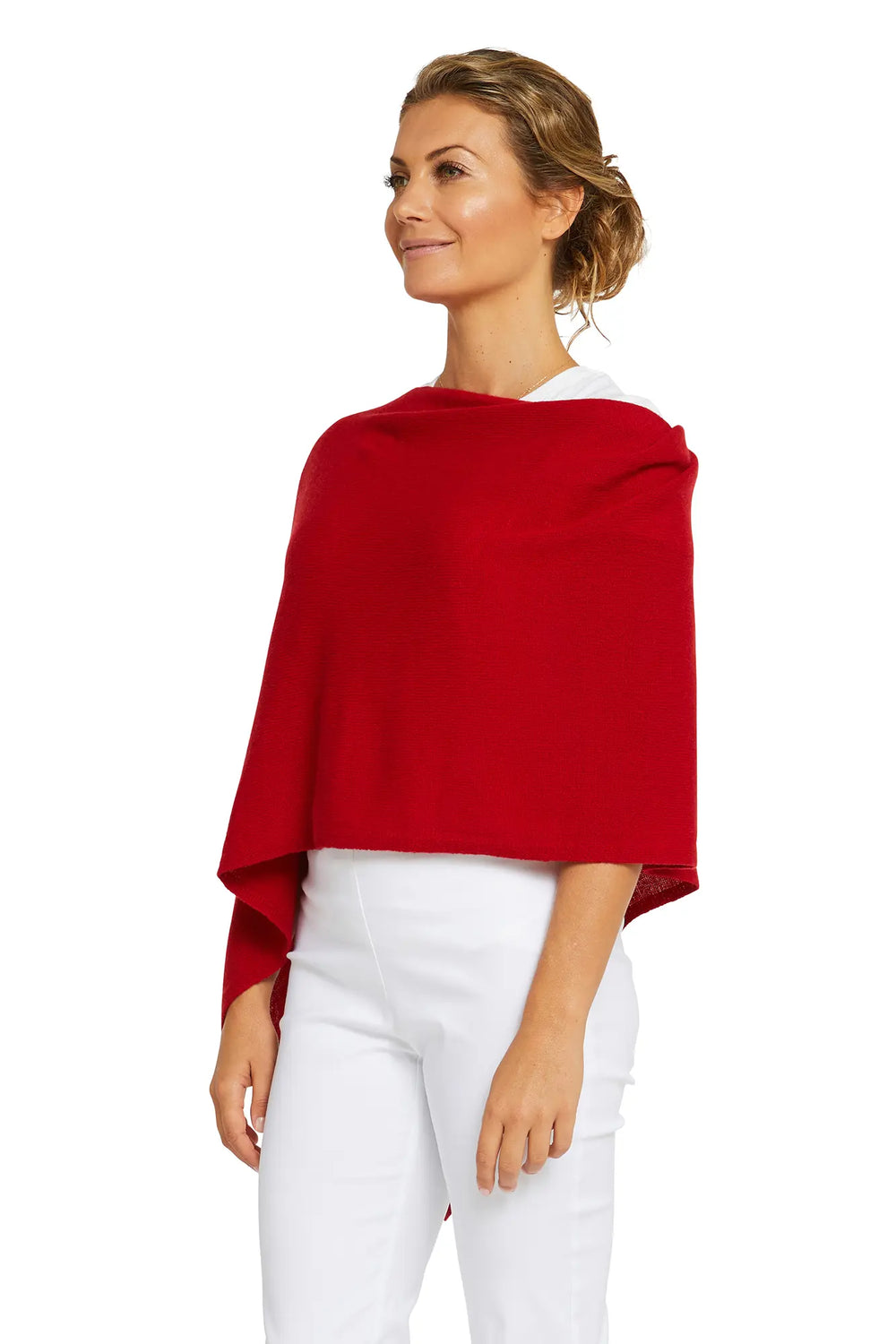 Woman wearing a red poncho over a white top and pants on a white background