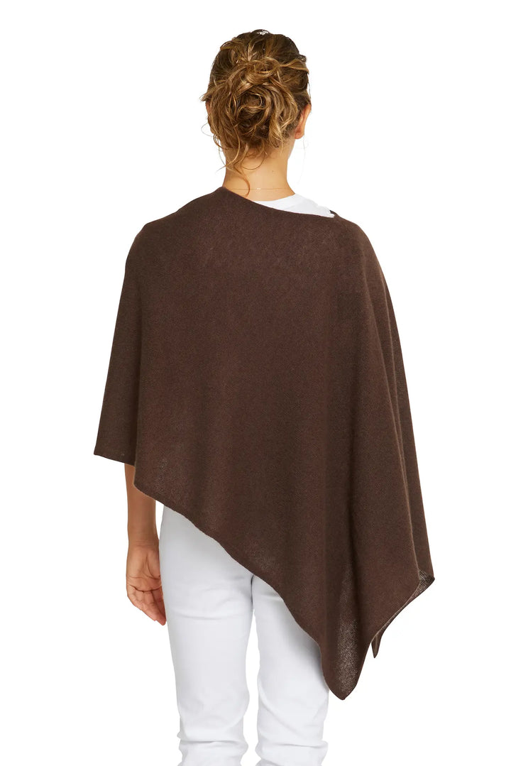 Person wearing a brown poncho over a white shirt and pants on a white background