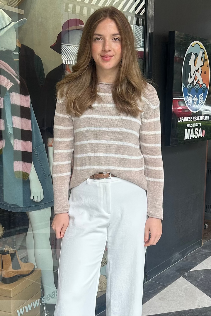 Woman standing on a black and white checkered floor in front of a store entrance.