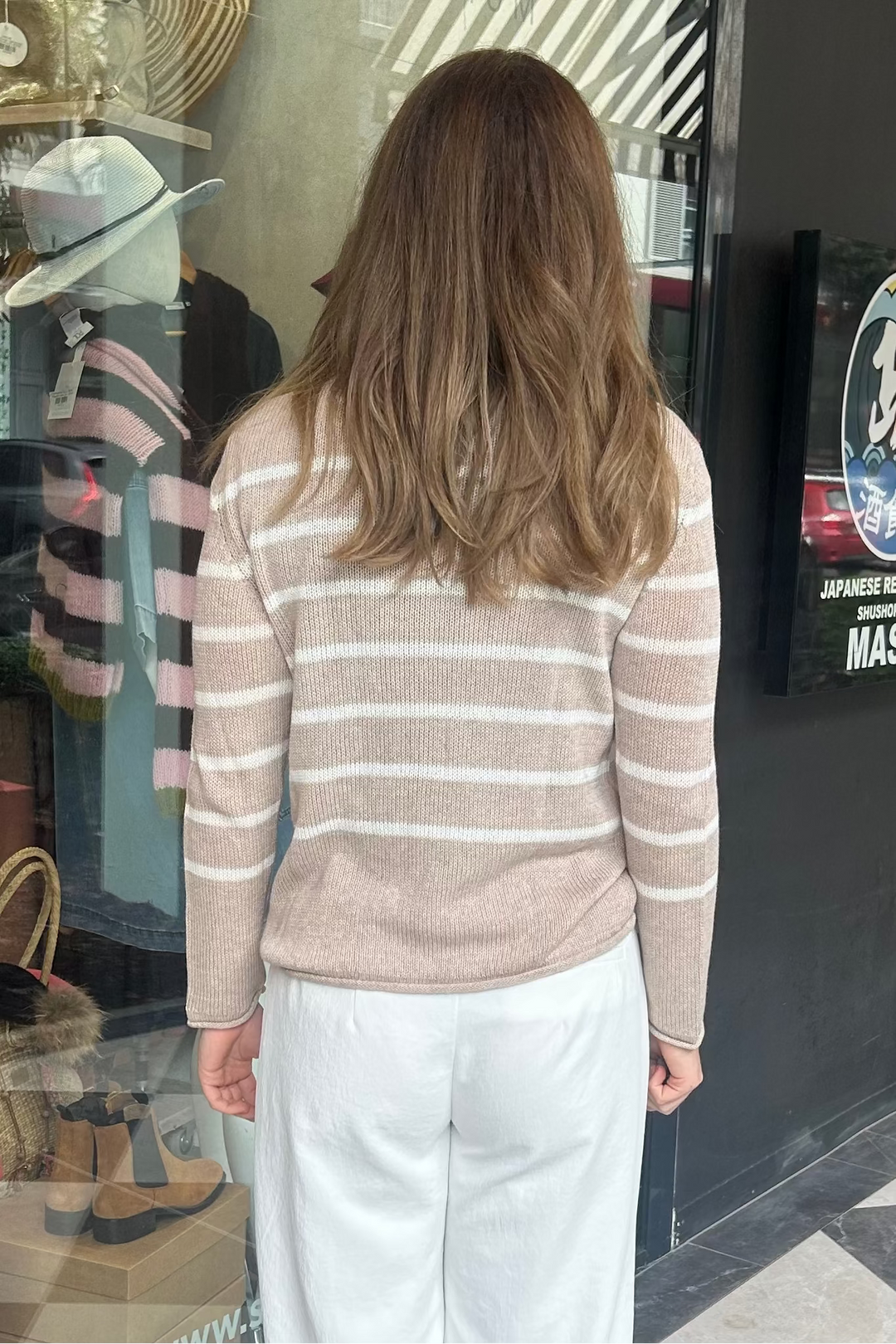 Woman standing in front of a store entrance with a checkered floor.