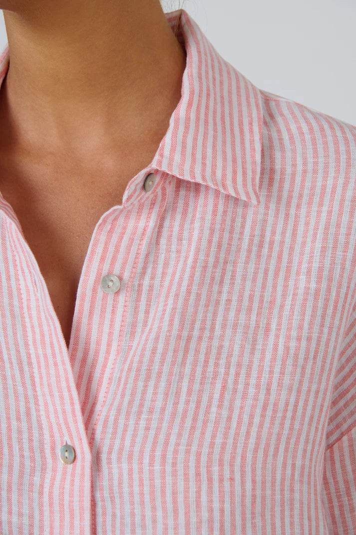 Close-up of a pink and white vertically striped button-down shirt worn by a model, showing the collar and front buttons.