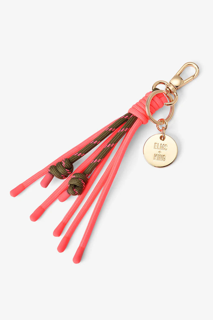 Keychain with coral tassels and gold tag on a white background