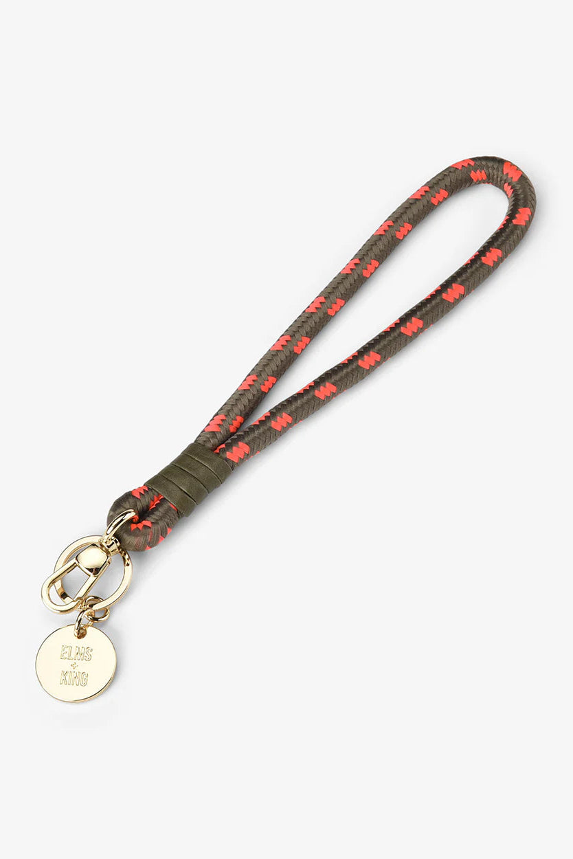Keychain with a patterned strap and gold tag on a white background