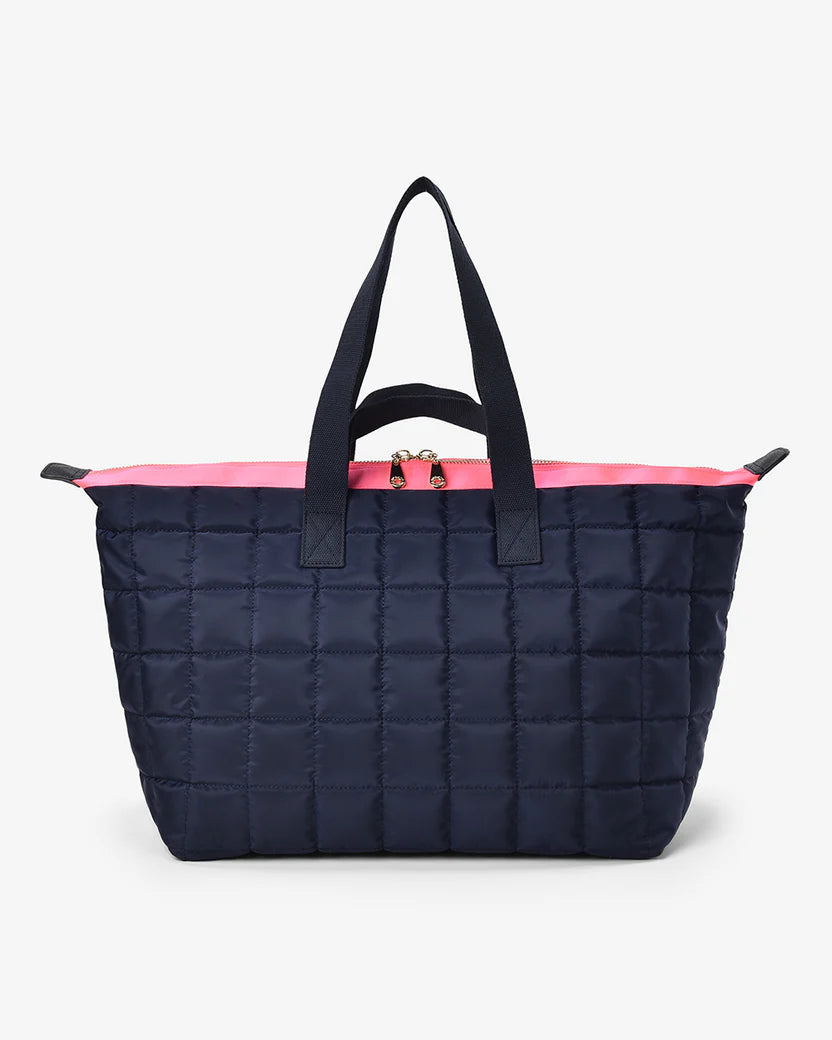 Navy quilted tote bag with pink interior lining on a white background