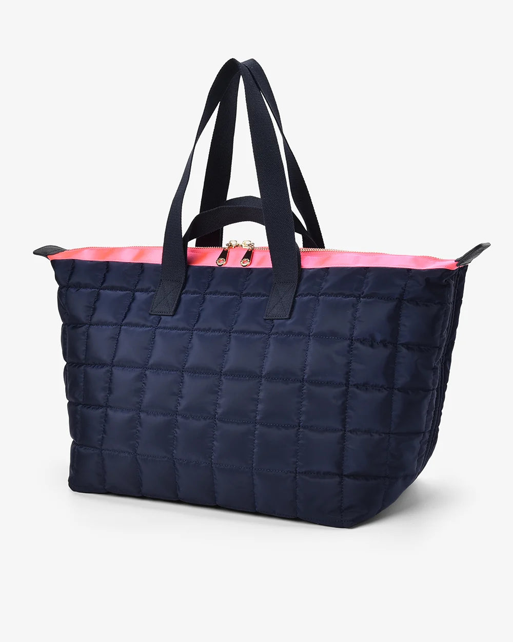 Navy quilted tote bag with black handles and pink interior on a white background