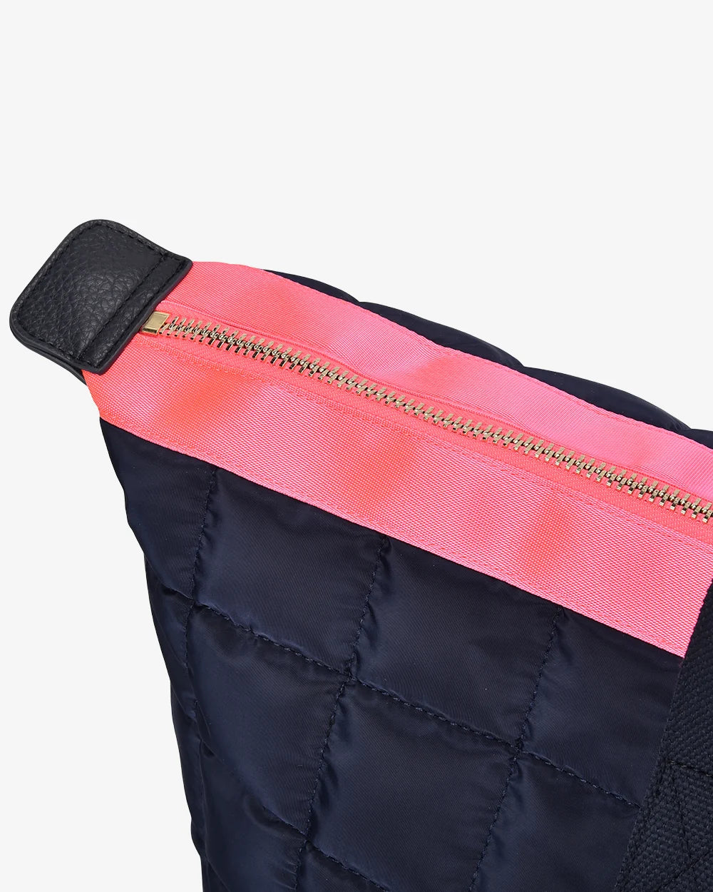 Close-up of a black quilted bag with a pink zipper on a white background