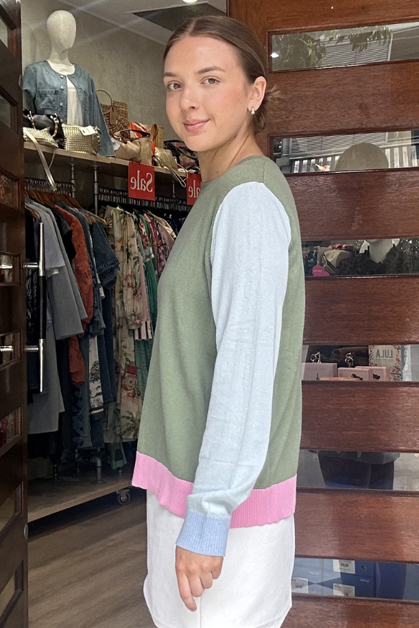 Woman standing in front of a store entrance with wooden slats.