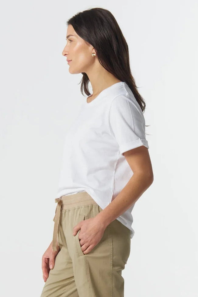 Woman wearing a white t-shirt and beige pants on a white background