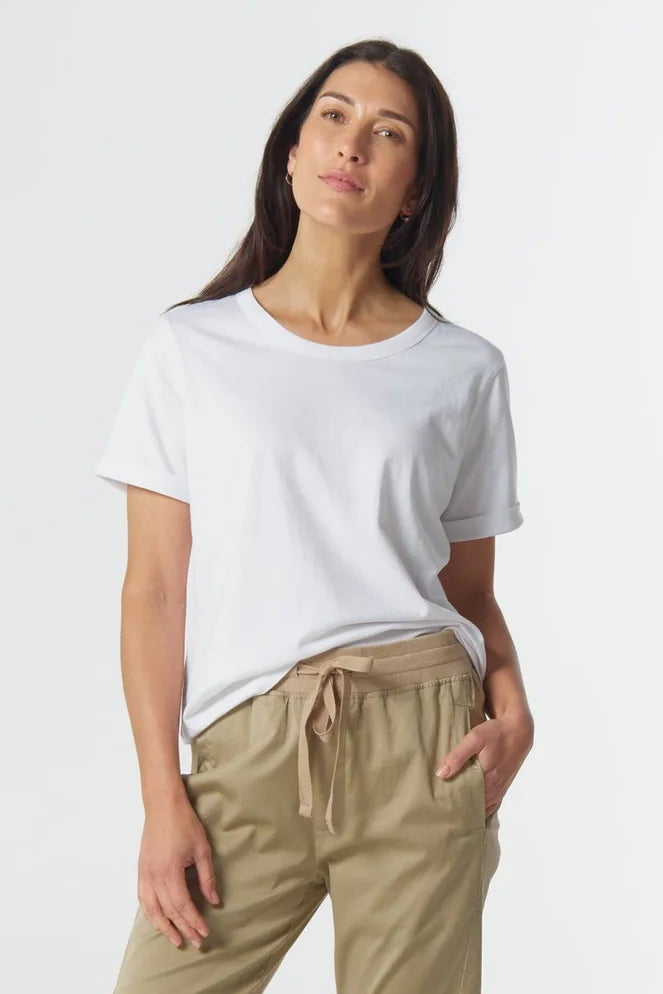 Woman wearing a white t-shirt and beige pants on a white background
