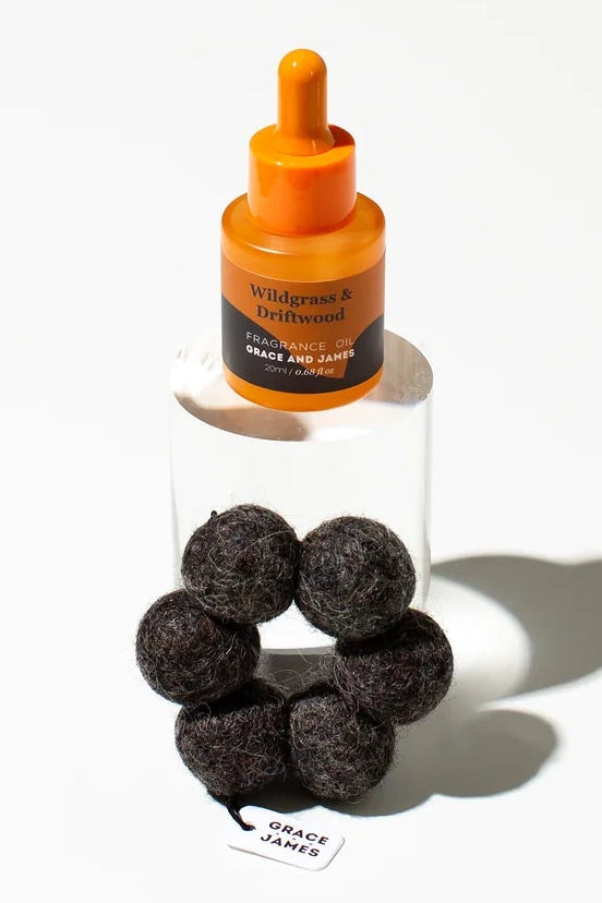 Orange bottle with dropper and dark spherical objects on a white background