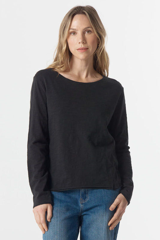 Woman wearing a black sweater and blue jeans on a white background
