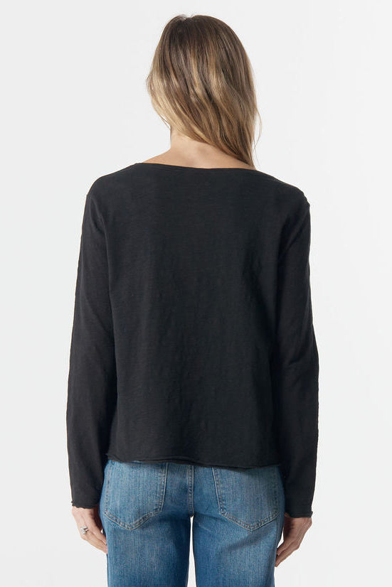 Person wearing a black sweater and blue jeans on a white background