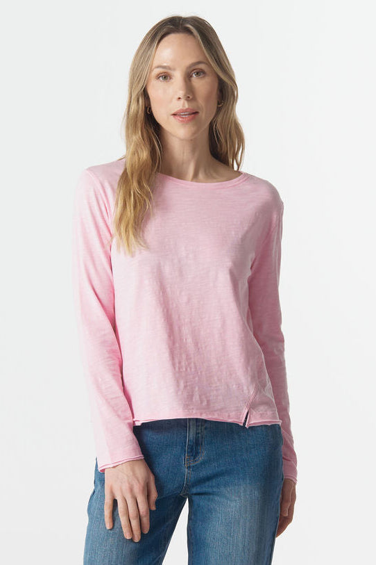Woman wearing a pink sweater and blue jeans on a white background