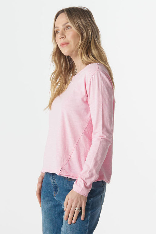 Woman wearing a pink sweater and blue jeans on a white background