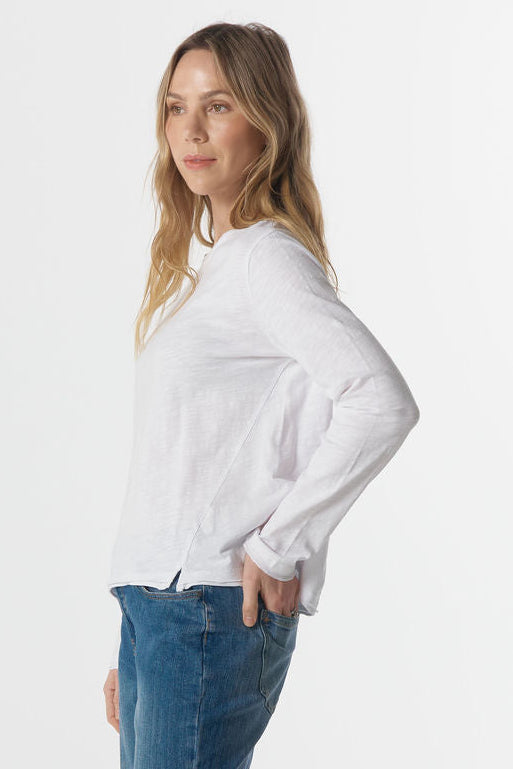 Woman wearing a white sweatshirt and blue jeans on a white background