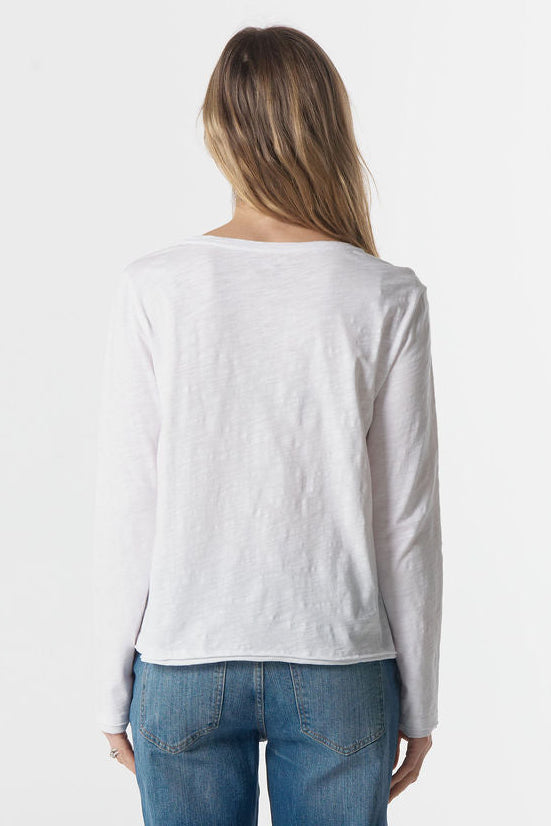 Person wearing a white long-sleeve shirt and blue jeans on a white background