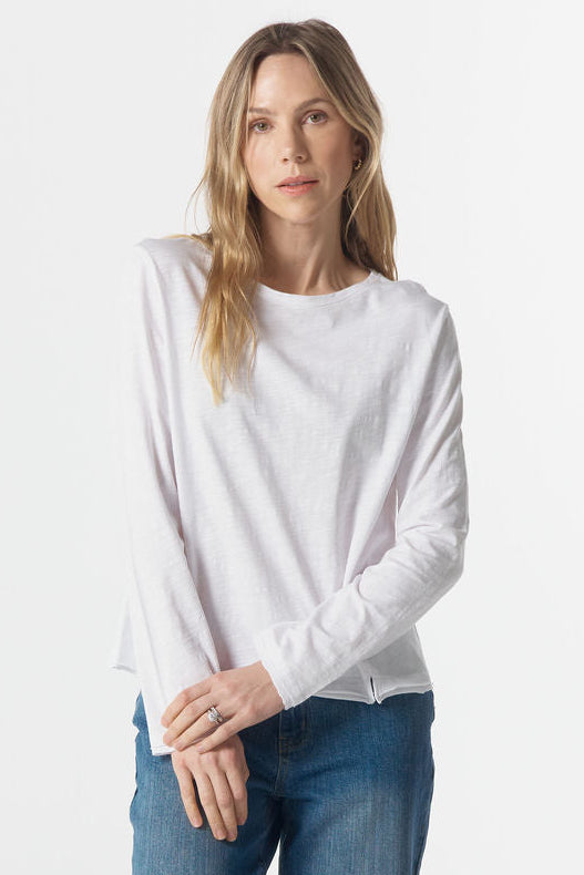Woman wearing a white sweater and blue jeans on a white background